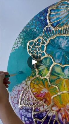 a person is painting a glass plate with flowers on it