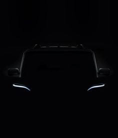 the front end of a black car in the dark