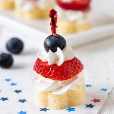 a red, white and blue dessert with strawberries on top is sitting on a napkin