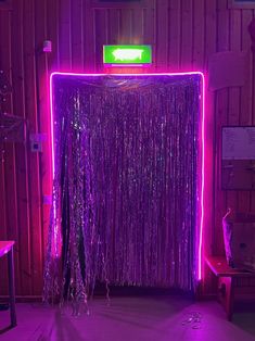 a room with purple tinsel and neon lights on the walls, along with a curtain that has fringes hanging from it