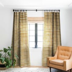 a living room with a chair, window and rug