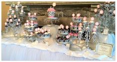 a table topped with lots of cakes and cupcakes