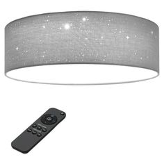 a remote control sitting next to a light fixture with stars on the fabric covering over it