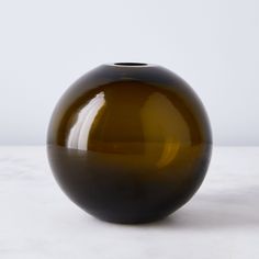 a brown vase sitting on top of a white table