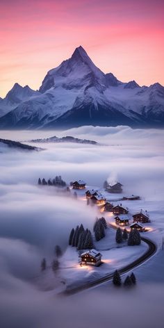 the mountains are covered in fog and low lying clouds at dusk, with small houses nestled among them