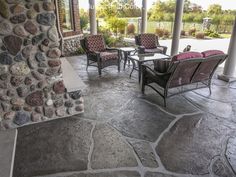 a stone patio with chairs and tables on it