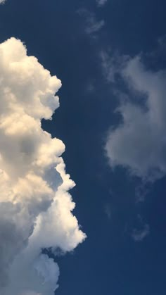 an airplane is flying in the sky with clouds