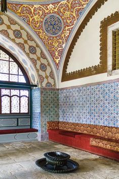 an ornately decorated room with blue and red tiles on the walls, windows, and floor