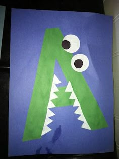 a paper bag with a green monster's mouth and eyes on it, hanging from a wall