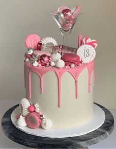 a birthday cake decorated with pink and white icing, candy, candies and decorations