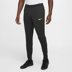 a man in black and yellow nike pants