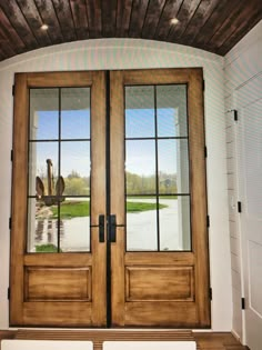 the front door to a house with two large doors and benches in front of it