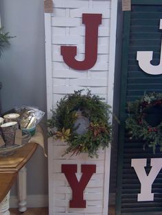 the letters j, y and y are made out of white bricks with wreaths on them