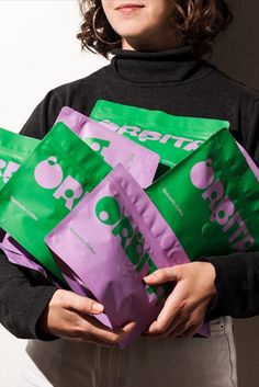 a woman is holding five bags of food