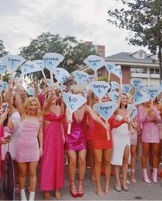 a group of women in dresses holding up signs