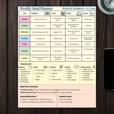 the weekly meal planner is on top of a wooden table next to a cell phone