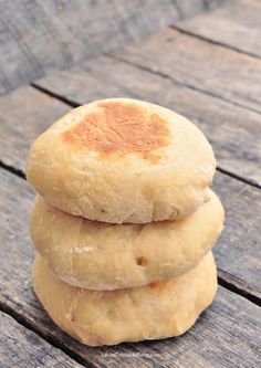 three round breads stacked on top of each other in the middle of a wooden table