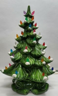 a green ceramic christmas tree with multicolored lights