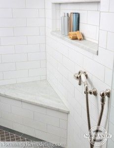 a white tiled shower with an open window