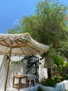 an umbrella sitting next to a small table under a tree