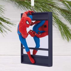 a spiderman ornament hanging from a christmas tree