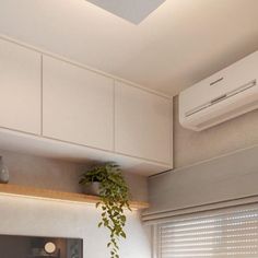 an air conditioner sitting on top of a window sill next to a plant