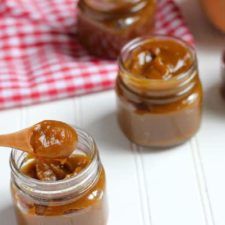 two jars filled with peanut butter on top of a table