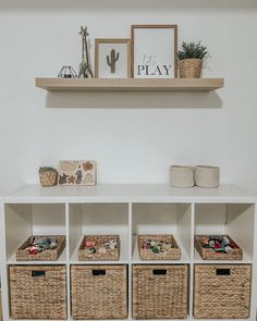 a white shelf with baskets and pictures on it