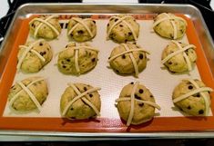 freshly baked chocolate chip cookies wrapped in white string on an orange tray with a black stovetop