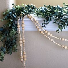 a bunch of beads hanging from the side of a window sill next to a plant