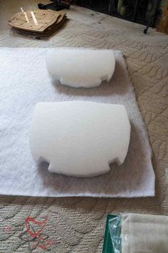 two pieces of white foam sitting on top of a table next to a piece of paper