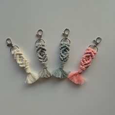 three key chains with tassels on them sitting next to each other in different colors