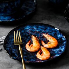 a plate with some shrimp on it next to a fork