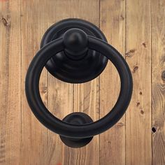 a black door handle on a wooden wall