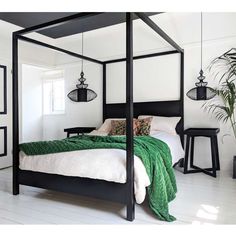 a black and white bedroom with four poster bed