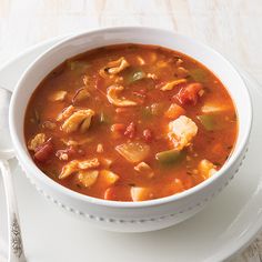 a white bowl filled with soup on top of a plate