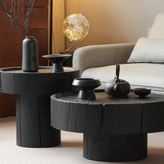 two black tables sitting next to each other in front of a white couch and chair