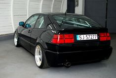 the back end of a black car in a garage