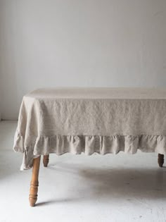 an old wooden bench with a linen cover on it