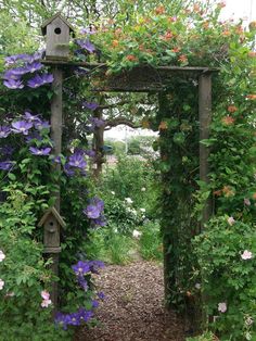 a birdhouse is surrounded by flowers and greenery