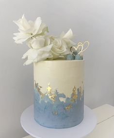 a blue and white cake with flowers on top