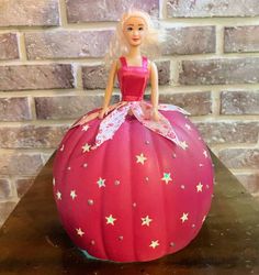 a barbie doll sitting on top of a pumpkin shaped like a ballon with stars