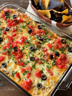 an enchilada casserole with tomatoes, black olives and cilantro