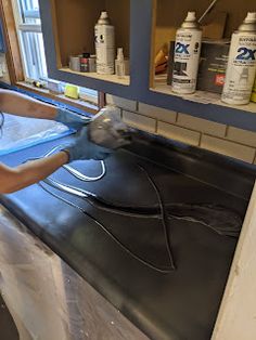 a woman is washing her hands in the kitchen sink while she's doing some work