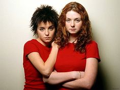 two women in red shirts are posing for the camera