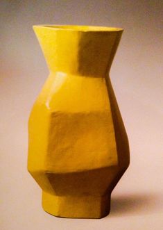 a yellow vase sitting on top of a table