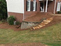 a brick house with steps leading up to the front door and side yard area,