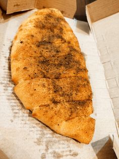 a piece of pizza sitting on top of a cardboard box