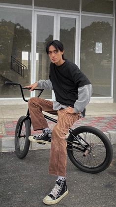 a young man sitting on top of a bike