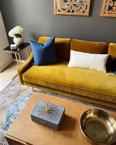 a living room with a couch, coffee table and two framed pictures on the wall